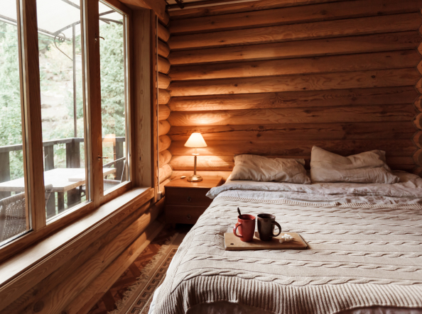 Bed in a cabin with coffee cups sitting on a board