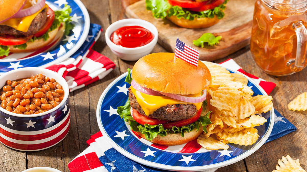 Red, white and blue dishes with burgers, chips and other cookout goodies