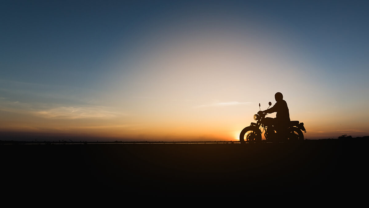 Silhouette of bike and biker with sunset in background