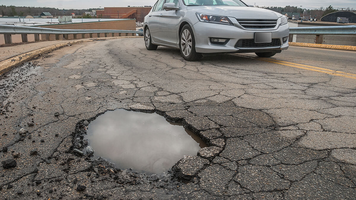 A close-up of a pothole filled with rain water