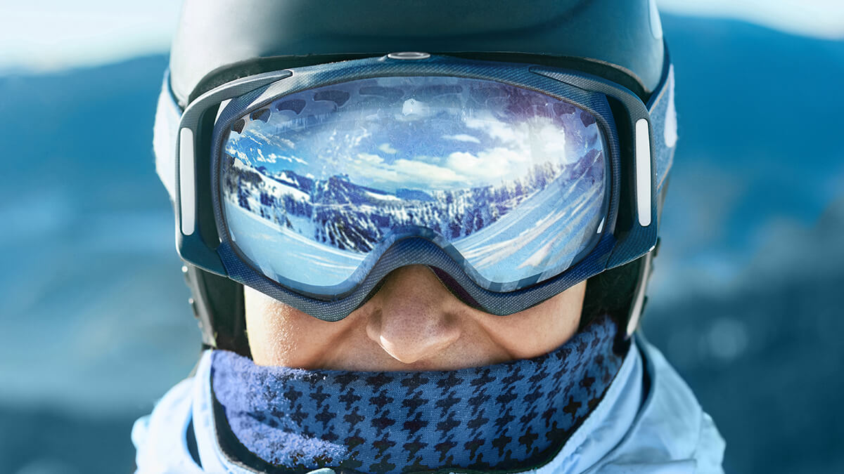 Man bundled up with helmet and mirrored ski goggles