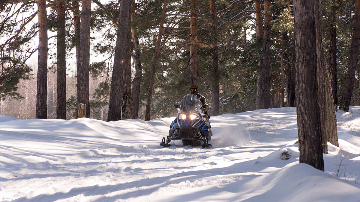 A snowmobiler dashing through the snow