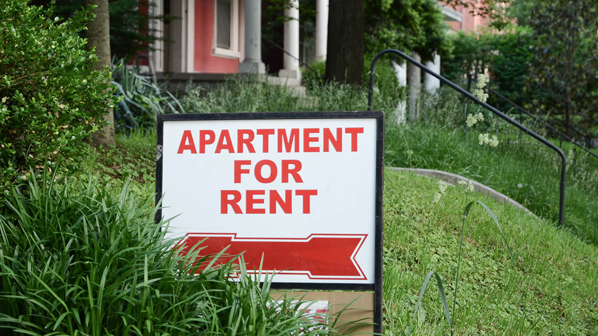 Red and white Apartment For Rent sign in front of property