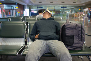 Man sleeping in an airport terminal with a book on his face