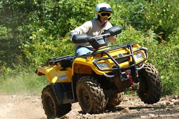 Man and machine - a man on an ATV tackling a rocky hill out in the woods