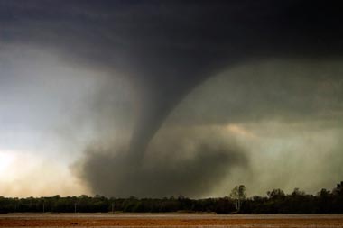 A menacing tornado in an open field