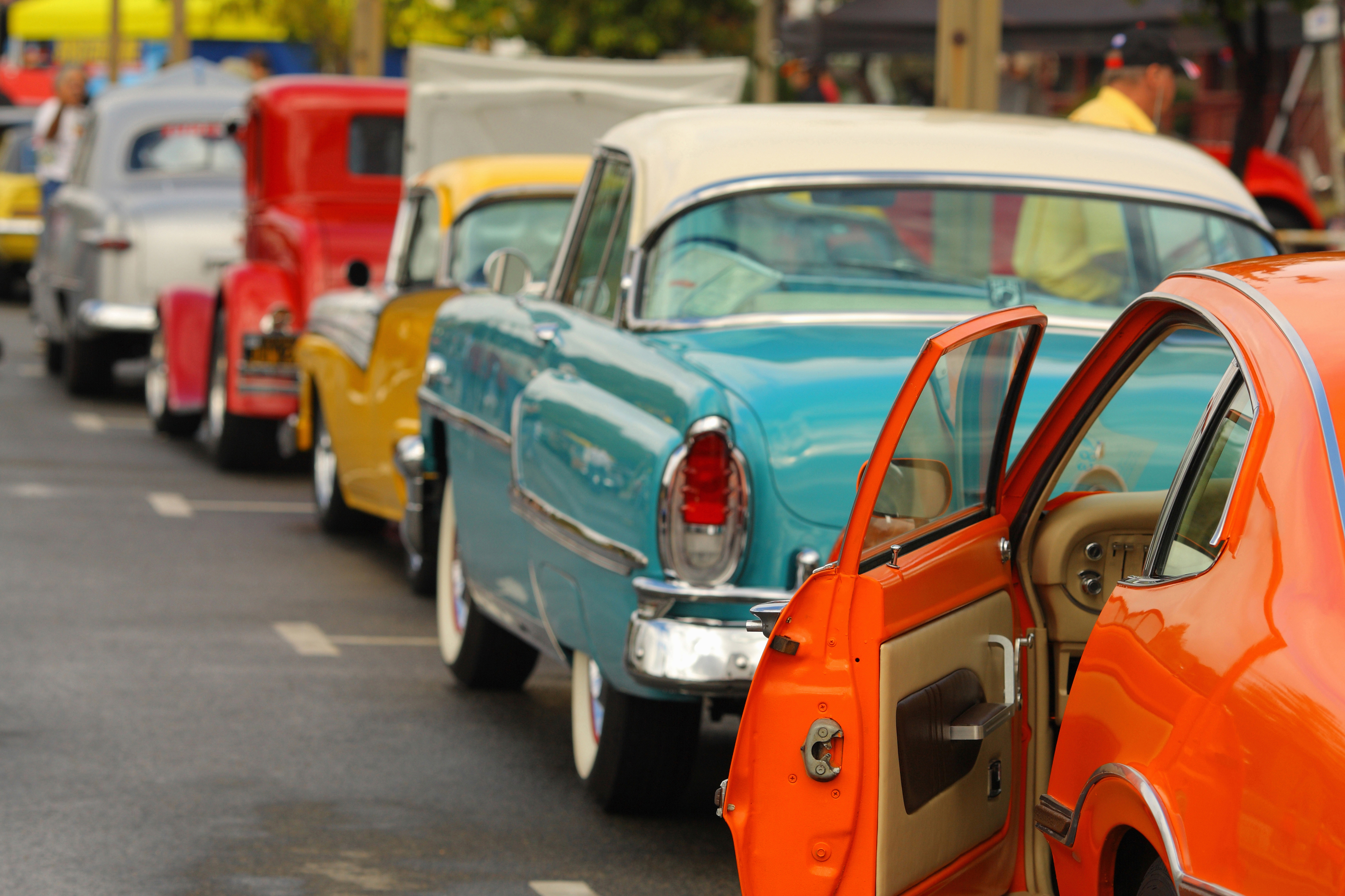 Brightly colored classic cars lined up on the street