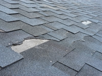 Loose and missing shingles on a roof