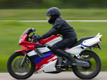 A motorcycle rider zipping by