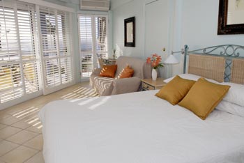 A bed room with savvy shutters.