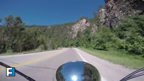 A first person view of motorcyclist riding through a canyon 