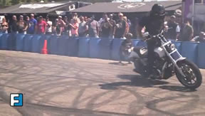 A stunt rider performing a standing donut